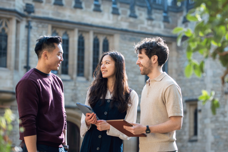 Three St Cross Students stand chatting in the quad